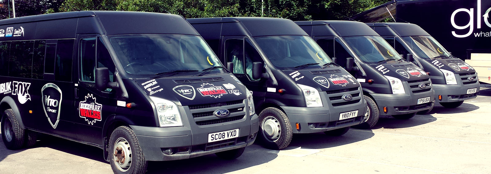 fleet of black vans with custom graphics