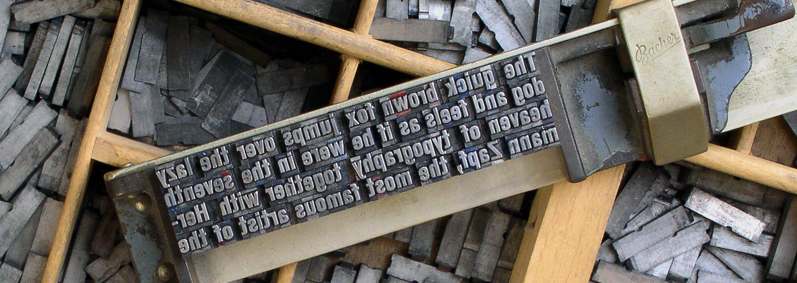 old fashioned letterpress block with selection of letter tiles in wooden trays